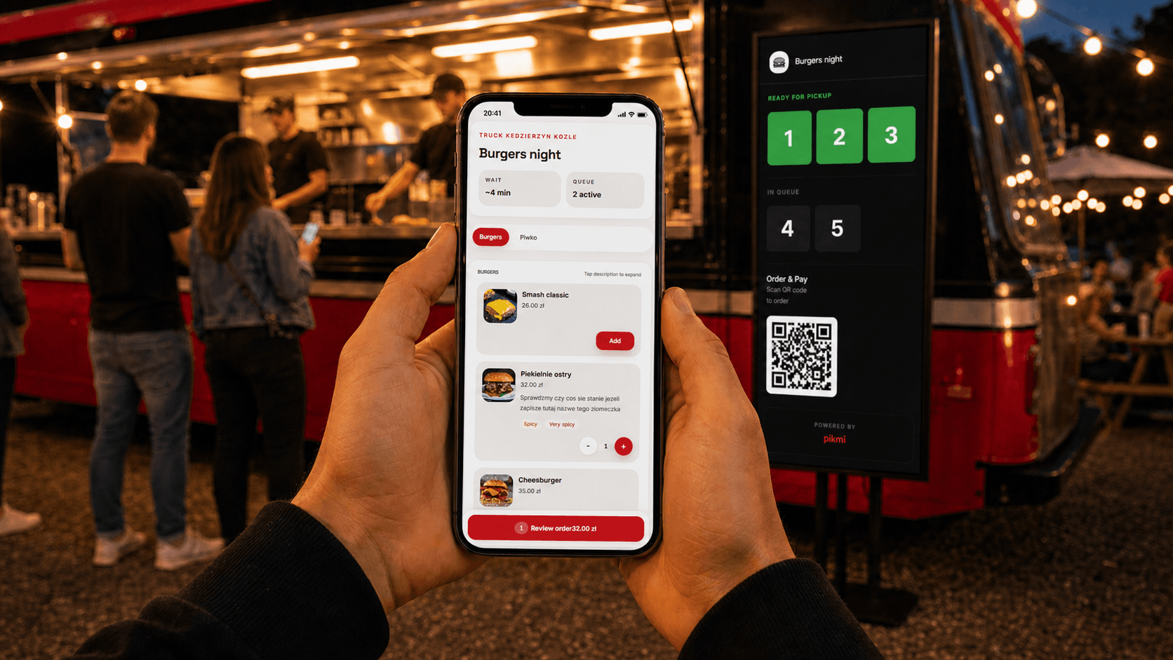 Klient zamawiający jedzenie z telefonu przy food trucku
