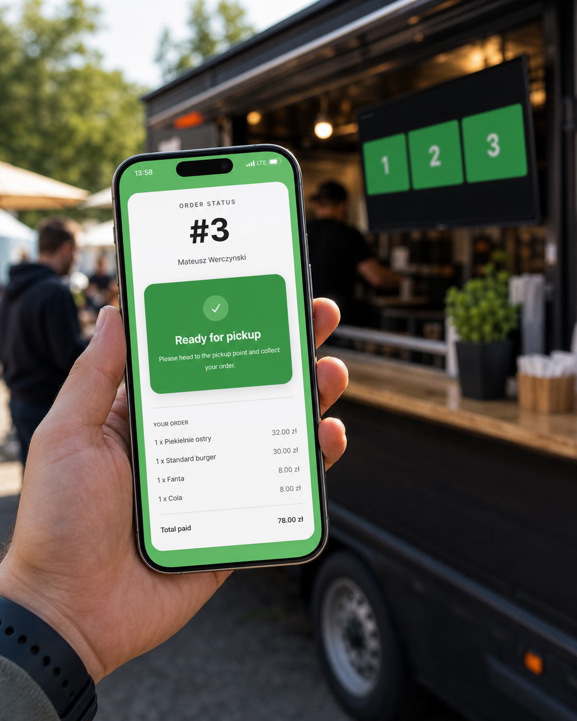 Telefon klienta ze statusem zamówienia przy food trucku